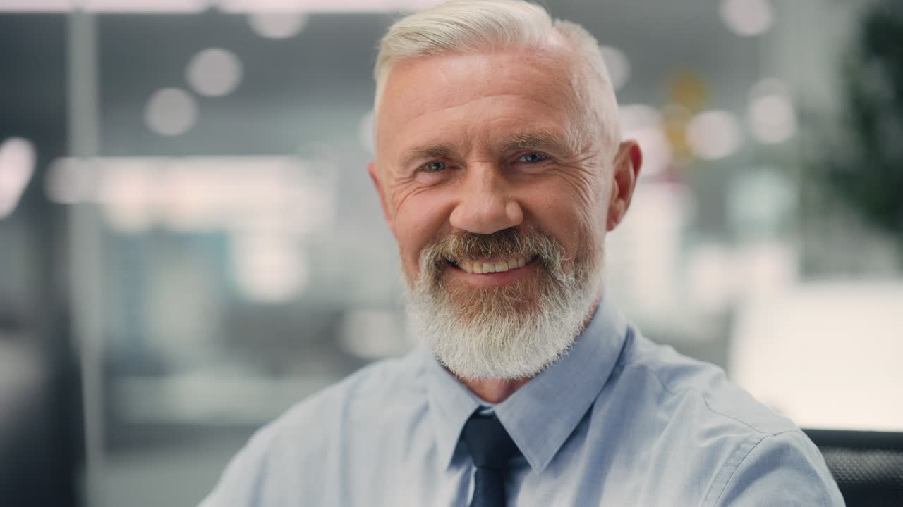 retrato de un hombre mayor feliz y confiado con camisa azul, mirando a la cámara, sonriendo genuina y encantadora. hombre mayor experimentado y exitoso que trabaja en diversas oficinas de la compañía.