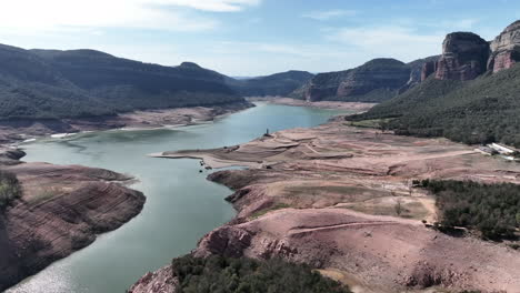 scenic sau reservoir aerial view flying across ter river blue sky mountain valley, catalonia, spain