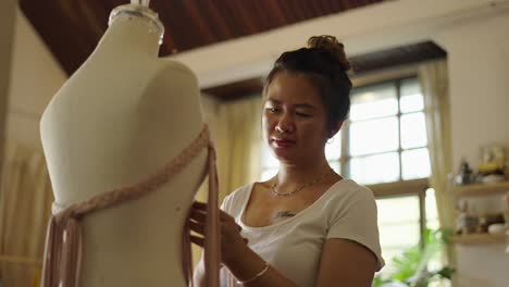 female artisan working on textile design with a mannequin