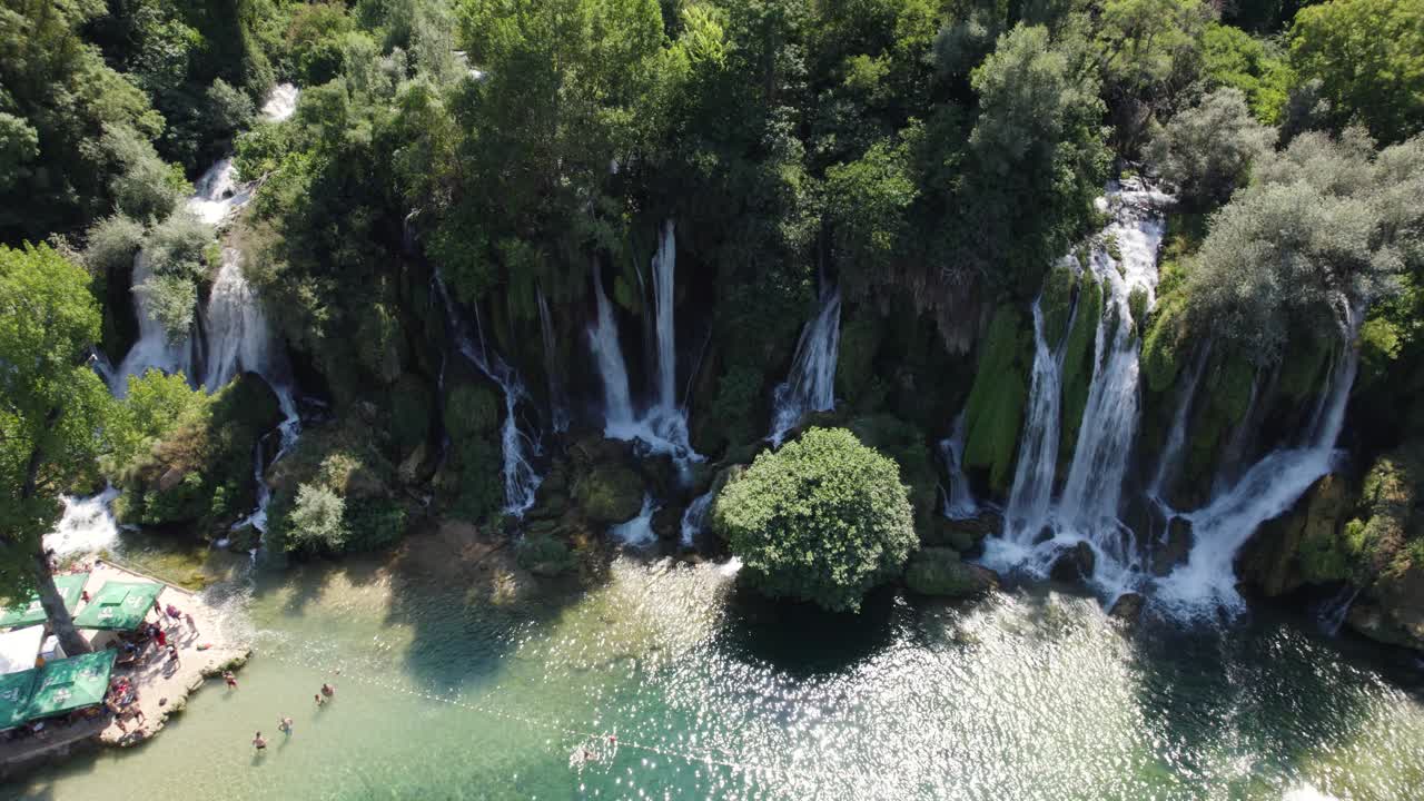 fotografía aérea estática de la hermosa cascada de kravica con personas nadando y tomando el sol, bosnia y herzegovina