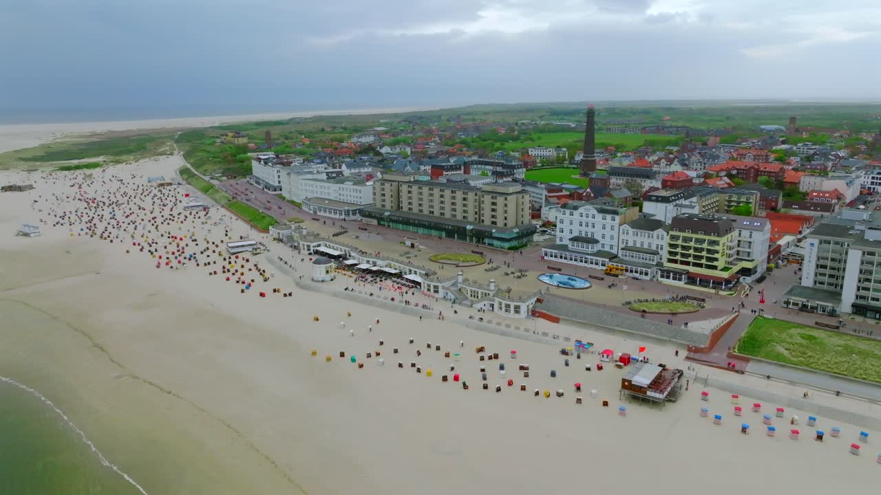 Bird's eye view of Borkum coastline with vast beach packed of colorful Strandkörbe and spa resorts and luxury hotels