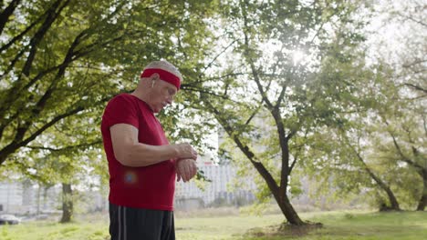 Älterer-Sportläufer,-Der-Mit-Einer-Smartwatch-Auf-Den-Touchscreen-Tippt-Und-Das-Ergebnis-Nach-Dem-Fitnesstraining-Verfolgt