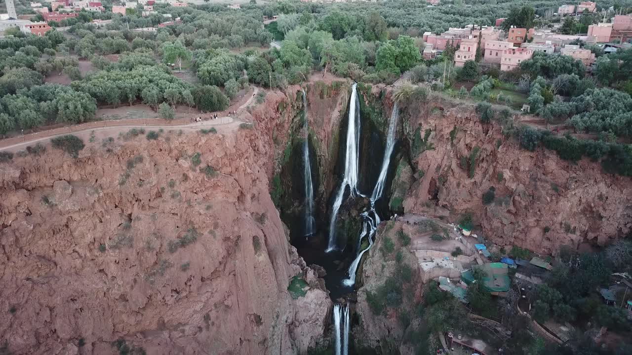 "Morocco's breathtaking Ouzoud cascades tumble dramatically from russet-colored precipices, where rushing waters form ethereal spray clouds above tranquil turquoise basins."