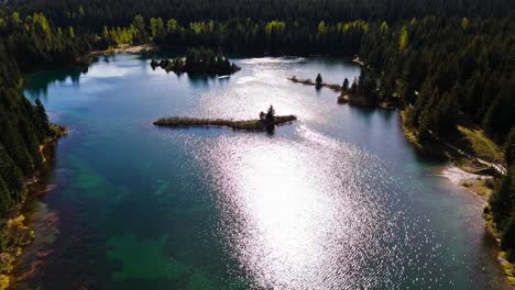 ascending aerial view of gold creek pond with clear blue water in washington state