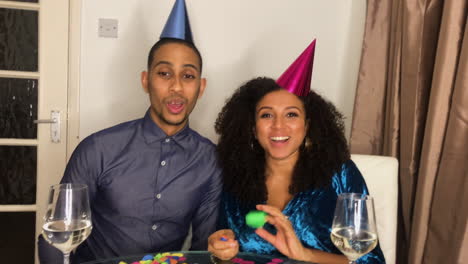 pareja de adultos jóvenes en videollamada contando hasta la medianoche y celebrando el cambio de año