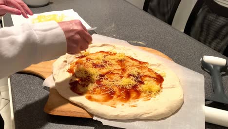 colocando queso y pollo a la parrilla en la masa de pizza