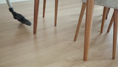 person vacuuming hardwood floor in living room