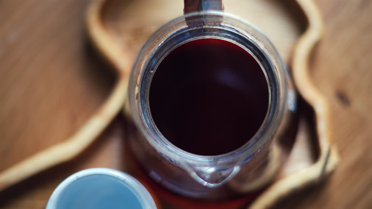 Close up of a glass coffee pot standing on a wooden tray
