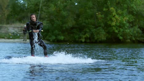 wakeboarder riding on tranquil water. male rider extreme life