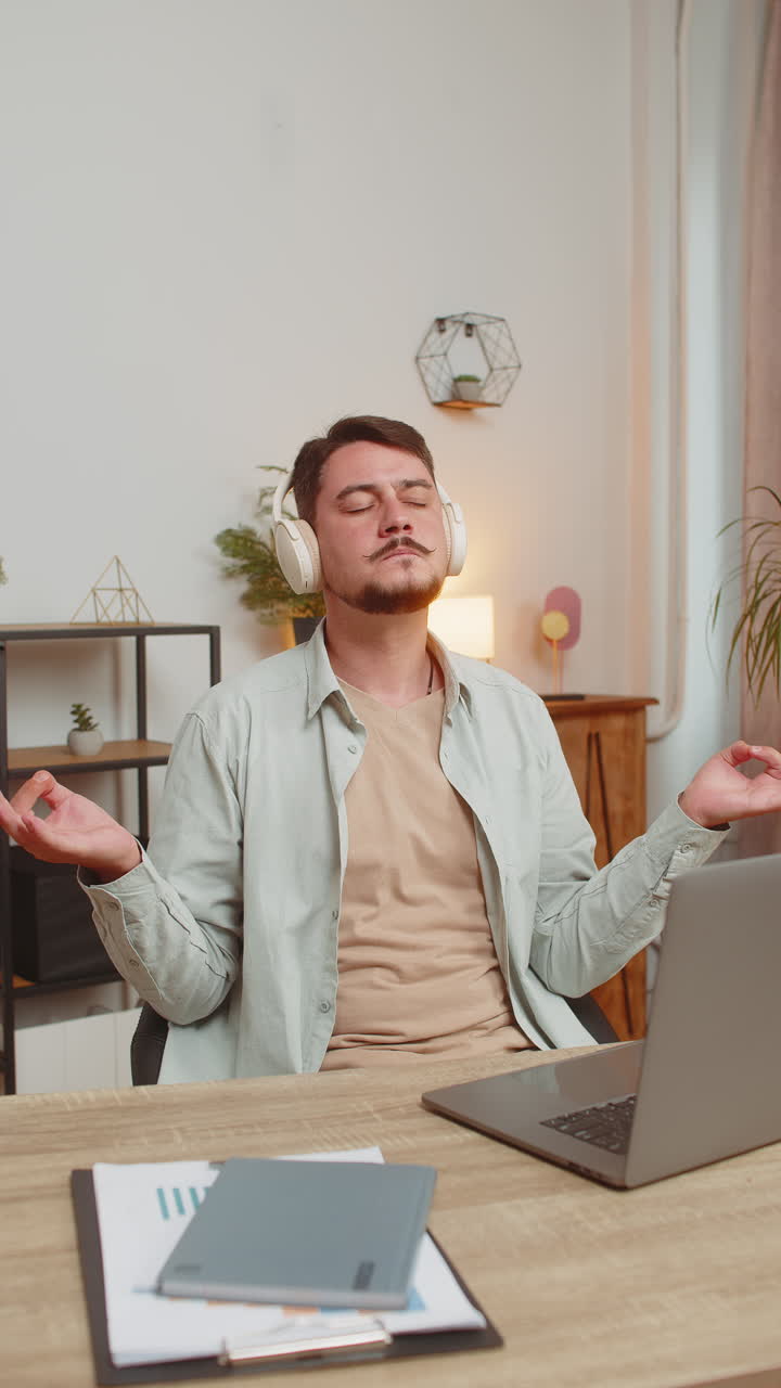 hombre escuchando música respira profundamente meditando con pensamientos concentrados mente pacífica en la mesa