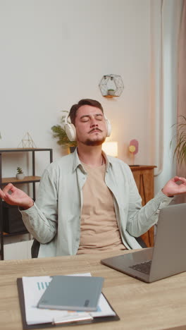 man listening to music breathes deeply meditating with concentrated thoughts peaceful mind at table