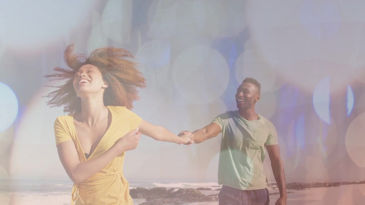 Joyful African American Couple Holding Hands on Sunny Beach with Bokeh