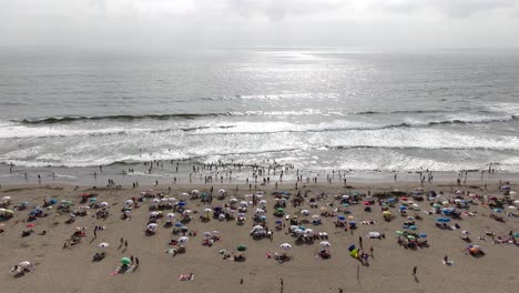 Aerial-View-Of-Maitencillo-beach-With-Beachgoers-And-Colourful-Parasols