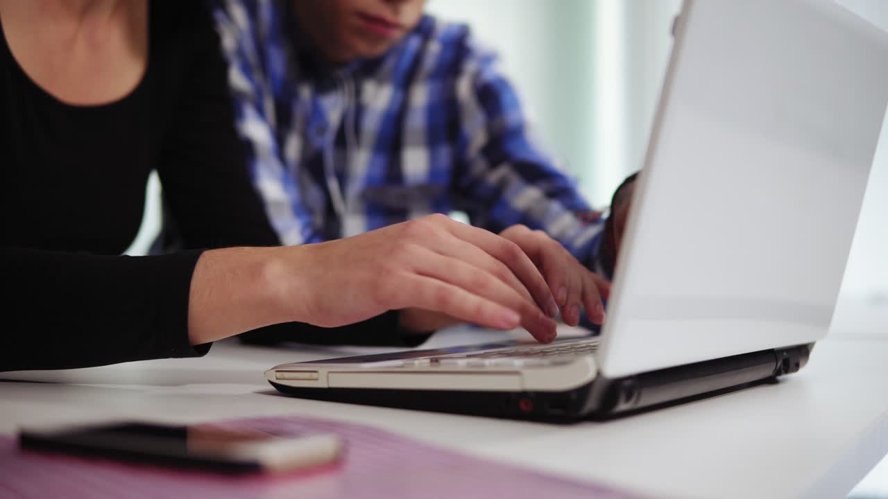 vista lateral de cerca de las manos de un equipo de negocios creativo irreconocible de tres personas que trabajan en la computadora portátil en una oficina moderna. están discutiendo ideas de negocios, mirando la pantalla y escribiendo