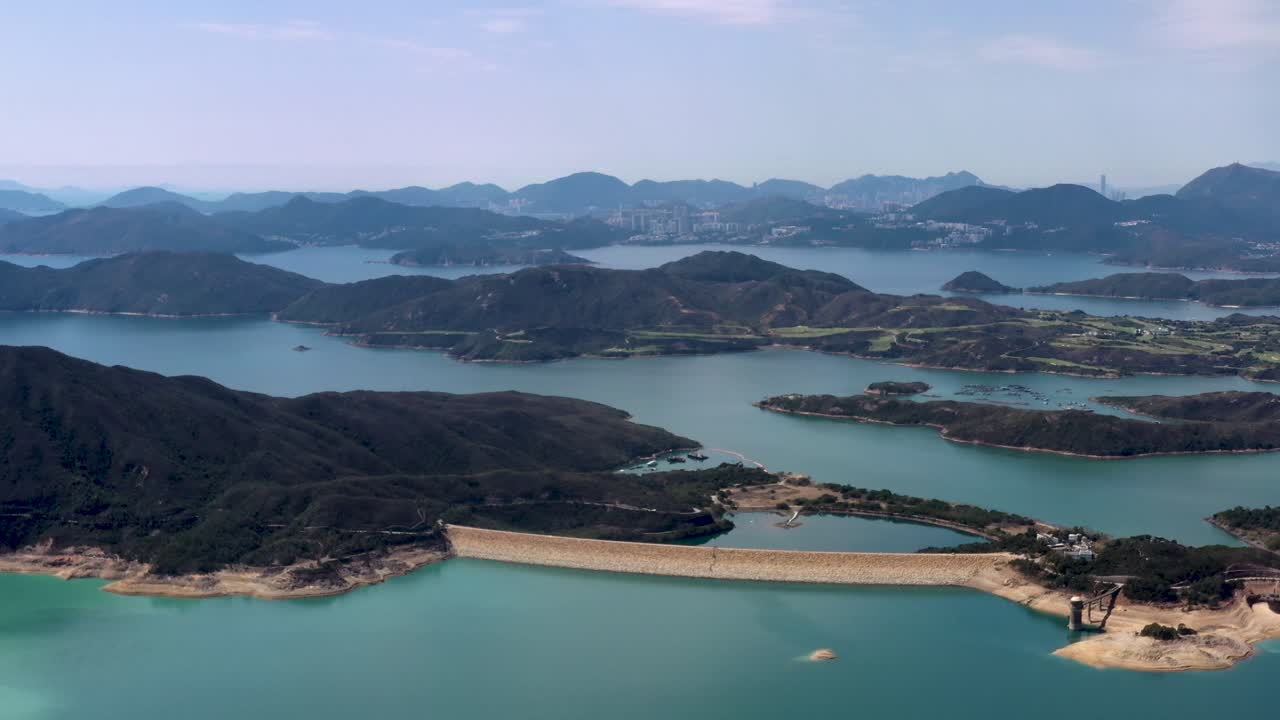 청록색 물로 둘러싸인 높은 섬 저수지 초록빛 섬과 언덕, 홍콩, 중국의 산쿵 반도의 공중 돌리