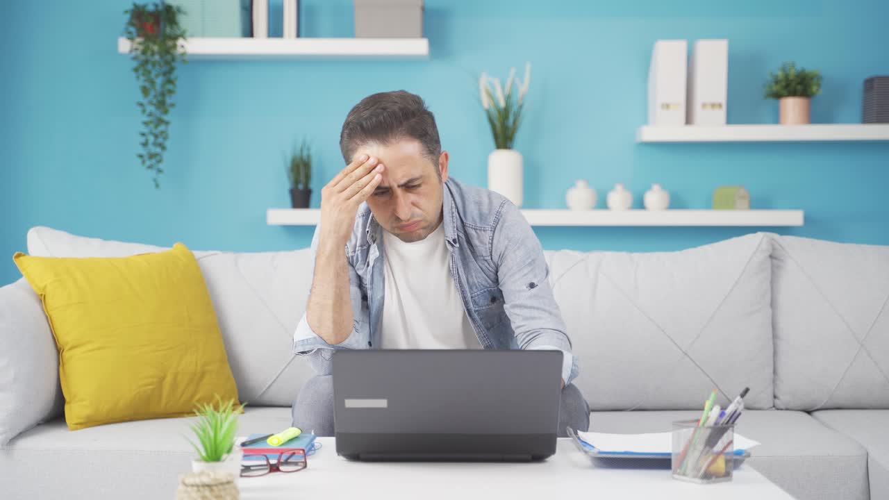 el hombre que trabaja en la computadora portátil tiene dolor de cabeza.