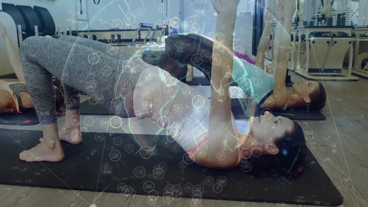Female participants lifting hips on class cue, pilates globe overlay tracking pulses for strength