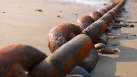 rusty anchor chain laid out on beach