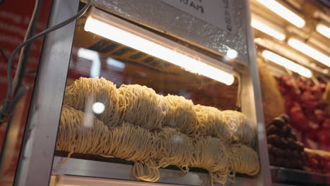 raw bakmie noodle display on glass cart handheld