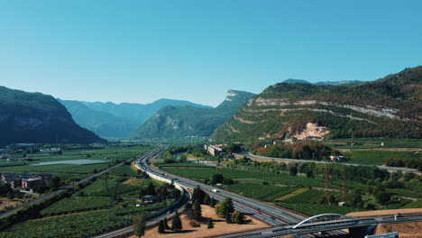 highway winding through alpine valley with vineyards