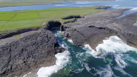 aerial reveal shot of coastline near bridge of ross rock formation