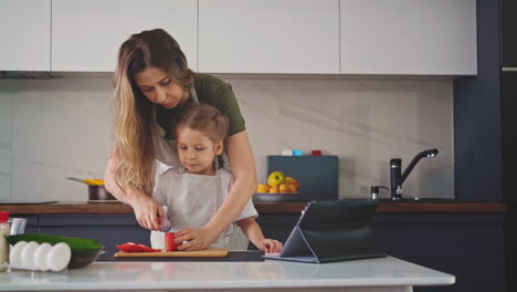 mother-in-gray-apron-stands-in-kitchen