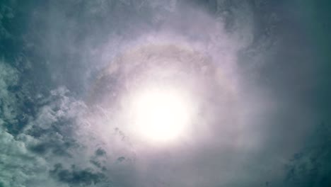 4k time lapse solar halo on blue sky white clouds,corona sun,optical phenomenon,with lens flare and white clouds flowing fast in the blue sky in summer day