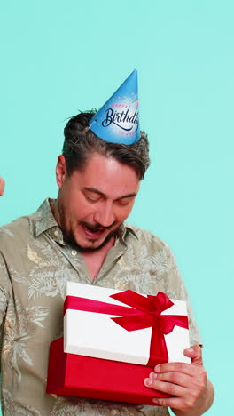 man wearing party hat happily receiving longawaited birthday gift showing excitement and gratitude