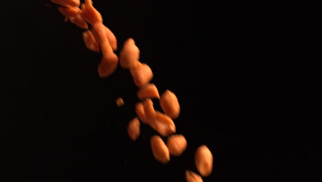 peanuts pouring against black background