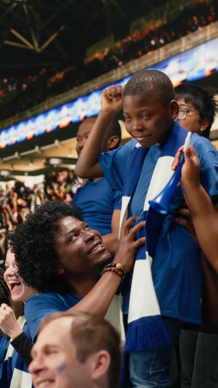 Video vertical de padres afroamericanos disfrutando de tiempo familiar de calidad en un estadio de fútbol