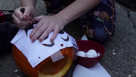 Primer-Plano-De-Mujer-Tallando-Con-Un-Cuchillo-Pequeño-Una-Calabaza-Naranja,-Halloween