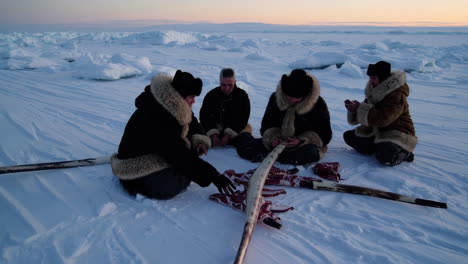 indigenous people in the arctic preparing animal hides