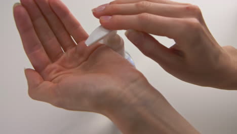 A-woman's-hands-pumping-hand-sanitizer-into-her-hand