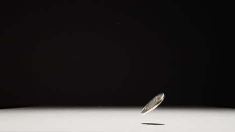 Japanese-100-Yen-Coin-Falling-Into-Frame-and-Bouncing-on-Table