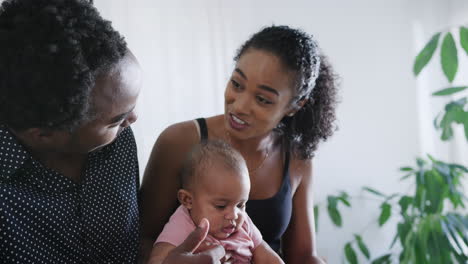 close up of loving parents playing with baby daughter sitting at home together