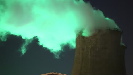 green smoke from chimney of night industrial cityscape with carbon emissions from factory