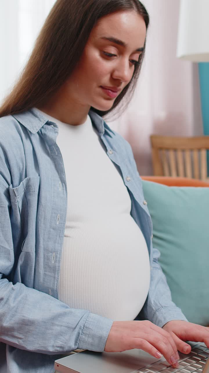 Pregnant woman using working on laptop communicating online browsing internet shopping social media