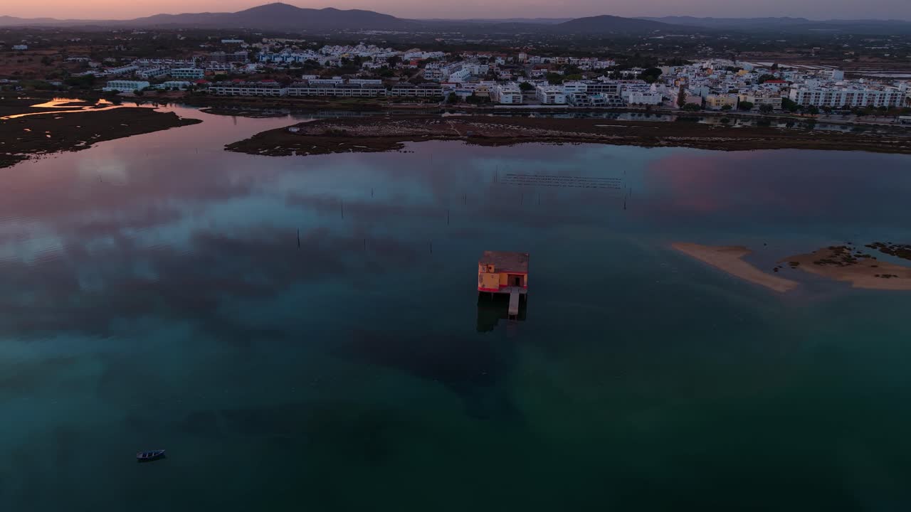 aerial shot around life boat station in Fuseta fishing village near Faro in Algarve region at sunset with beautiful colors, Portugal
