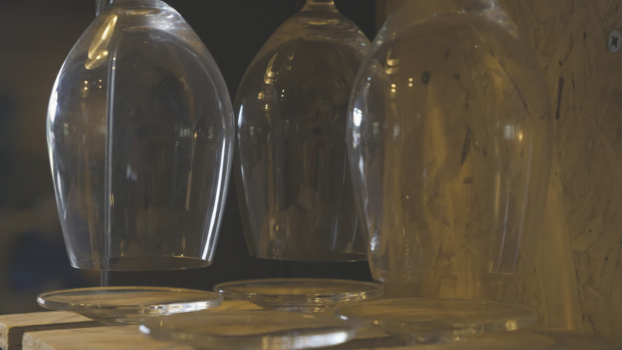 3 copas de vino cuelgan boca abajo a la espera de ser utilizadas, la cámara se mueve lentamente
