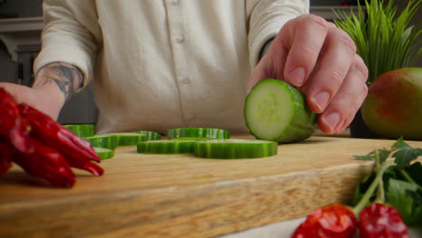 preparing sliced cucumber and chili peppers for salad