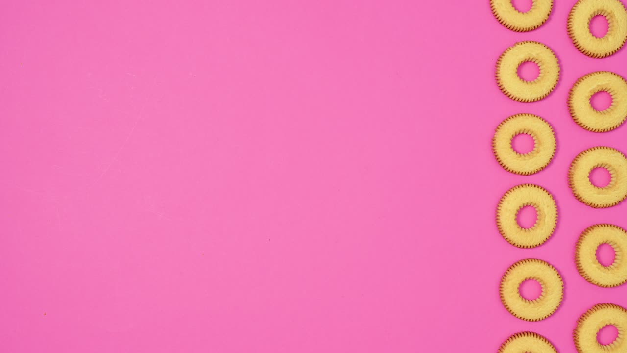 galletas redondas en dos columnas se mueven en el lado derecho del tema rosado vibrante. detener el movimiento plana