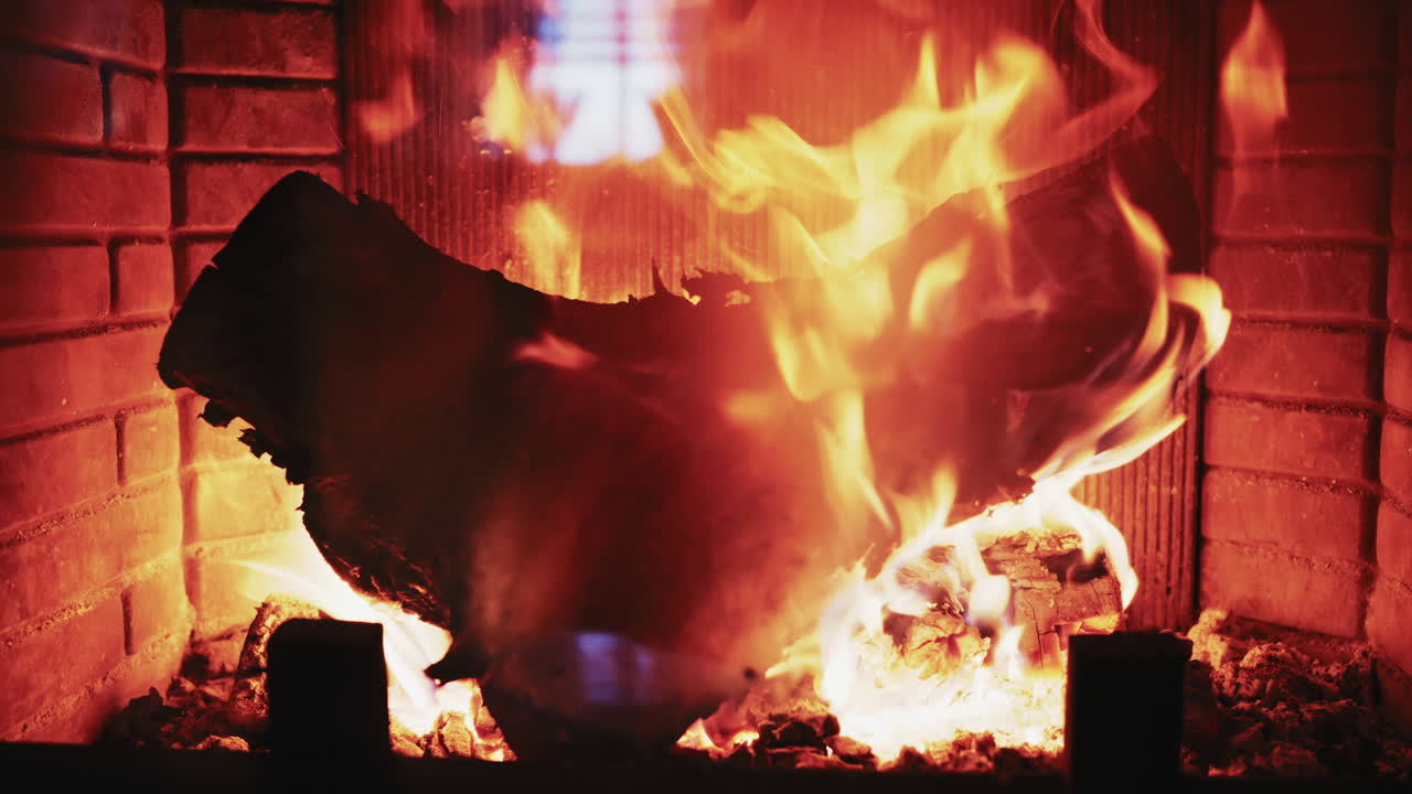 Legna da ardere in un caminetto con braci incandescenti e fiamme calde