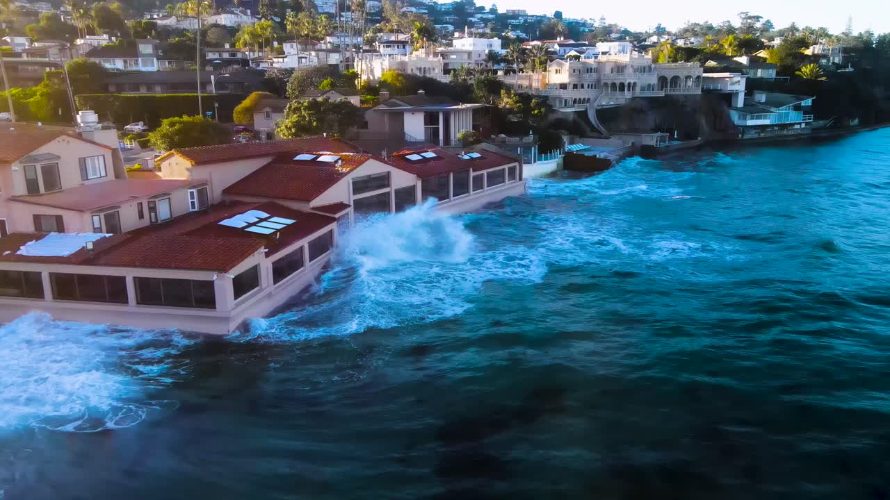 vista aérea de las mareas reales golpeando las casas frente al mar