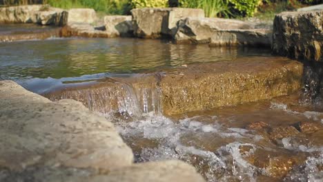 a small stream flowing over rocks in a garden