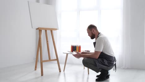 a man is a professional artist who paints a picture in his studio the concept of creating art - a man is a professional artist who paints a picture in his studio. the concept of creating art