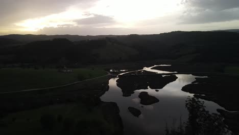 Sunset-light-reflects-on-marsh-moor-water-of-river-bank-stream-swamp