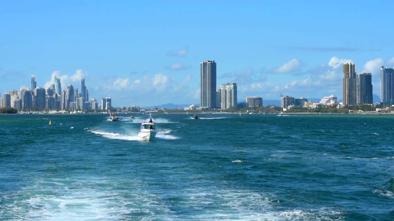 toma de seguimiento súper suave de una moto de agua mientras corre sobre el agua en una nube de rocío, bajo el glorioso sol tropical en la costa dorada de australia