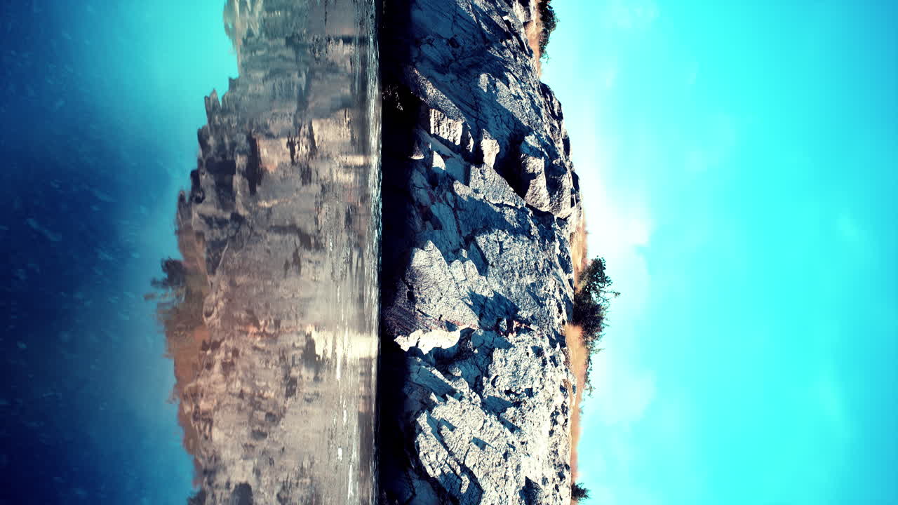 바 ⁇ 물 한가운데에 있는 큰 바위 섬의 수직 비디오