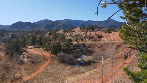 reveal shot, from behind an evergreen, of red rock open space in colorado springs, colorado