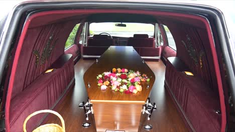 closeup shot of a funeral casket in a hearse or chapel or burial at cemetery